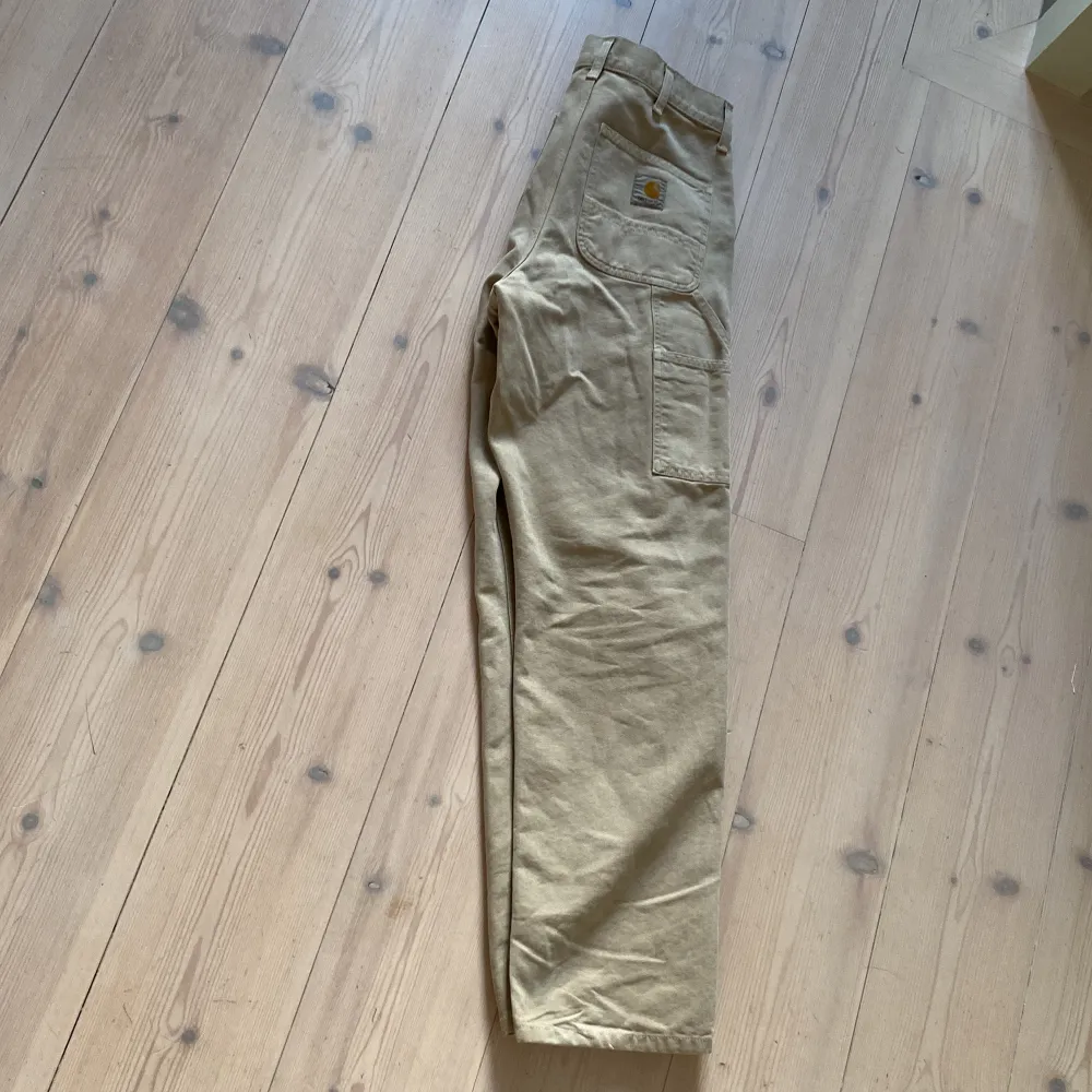 Beiga Carhartt carpenter pants, köpta på NK för 1600kr o använda Max 3 ggr, i nyskick. Dåligt ljus på bilderna, skriv för mer bilder!. Jeans & Byxor.