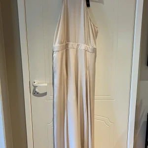 Byxdress halterneck  - Snygg byxdress med vida ben och halterneck. Storlek XL Passade inte mig så den är aldrig använd, lappen finns kvar 