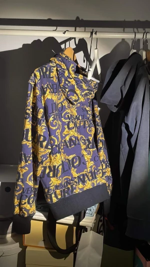 Versace jeans Couture hoodie - Versace jeans couture hoodie säljes i befintligt skick. Fin versace tröja i använt skick. Har enbart tröjan men kan garantera att den är äkta! Ordinarie pris 4500:- Mitt pris 1700:-