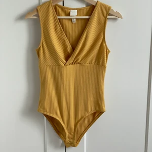 Senapsgul body - Vad: Så himla fin body, men färgen passar inte mig, även om jag skulle vilja🥰 Märke: hm Storlek: S Material: 92% polyester 8% elastan  Skick: Inget anmärka på 