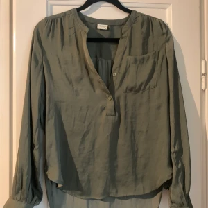 Skjorta  - Grön Skjorta i silkesyntes, använd ett fåtal gånger så är i väldigt bra skick! Den skiftar lite i färg beroende på ljus (se bilder). Storlek 34 men passar för större då den är loose 🥰 pris kan diskuteras vid snabb affär!