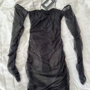 Helt ny mesh of shoulder svart klänning från PLT i storlek 34. Som sagt mesh, därav genomskinlig och stringbody under. 