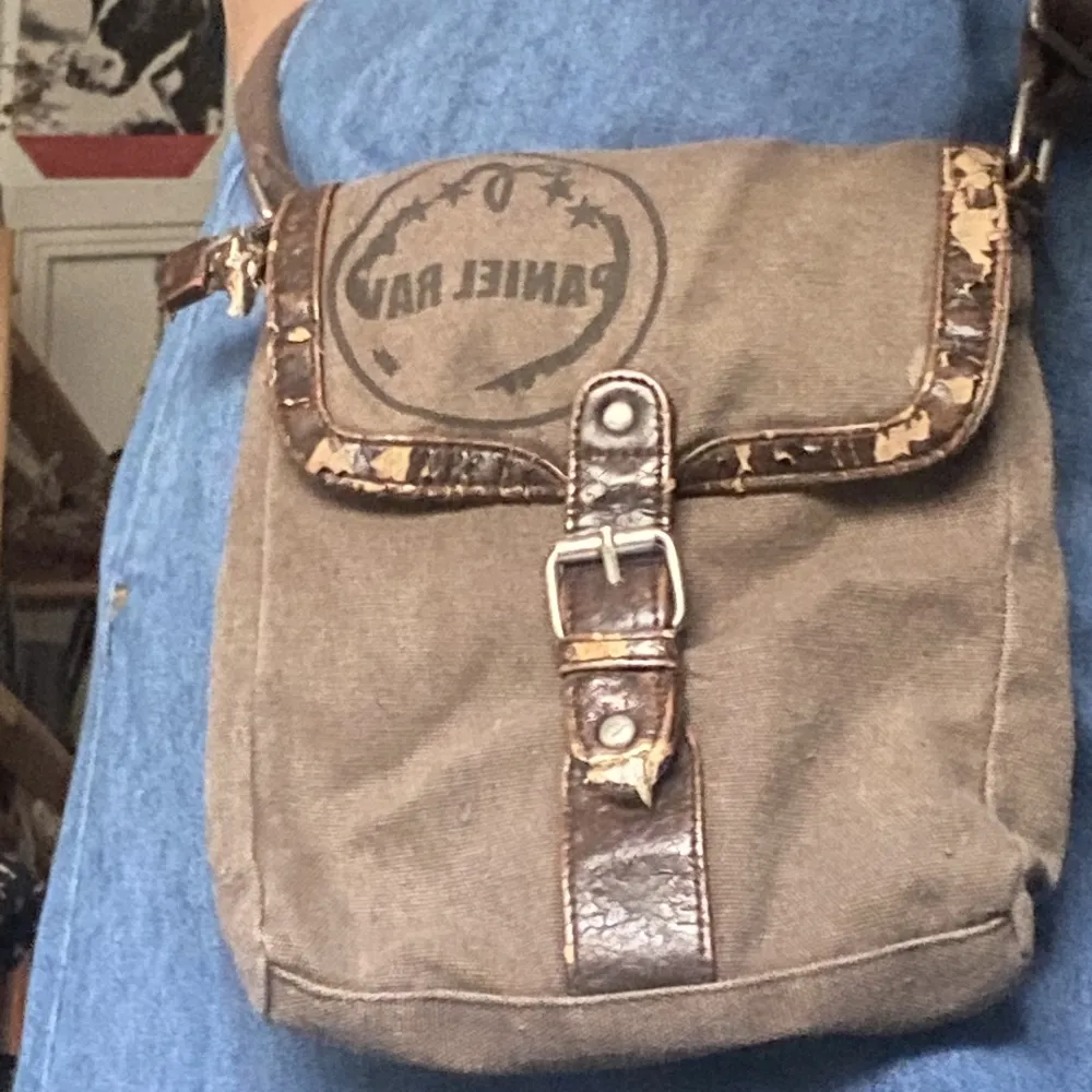 Liten brun väska med läderdetaljer från det tidiga 2000-talet. Dragkedjan till mig en av facken fungerar inte men det märkt inte av. Accessoarer.