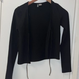 Kofta med snören  - Fin svart kofta me snören. Fin ribbad kofta. Jag säljer den för jag inte andvänder den längre 