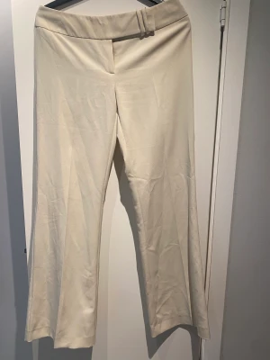 Low Waits kostymbyxor  - Ett par beiga lågmidjade kostymbyxor med snygg knäpp detalj. Köpta för 400, säljer för 150. (Köparen står för frakten) ❤️
