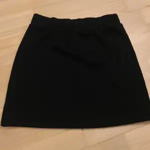 en svart bekväm kjol från Lindex, är i barnstorlek men sitter tjat och bra som en XS. Dragkedjan är dekoration.
