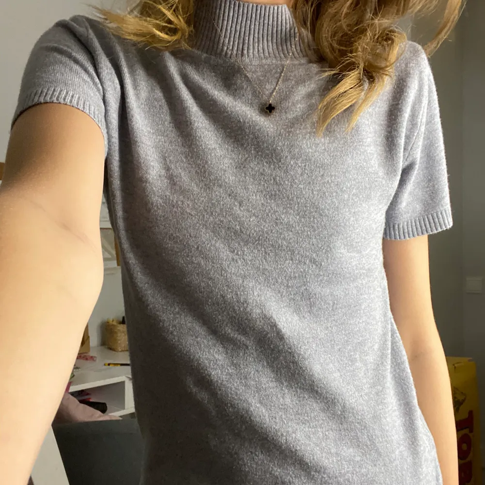 En grå stickad T-shirt, endast testad och är i nyskick. Köpte den för 90kr och säljer den för 70kr. Säljer pga att jag köpte en annan . Stickat.