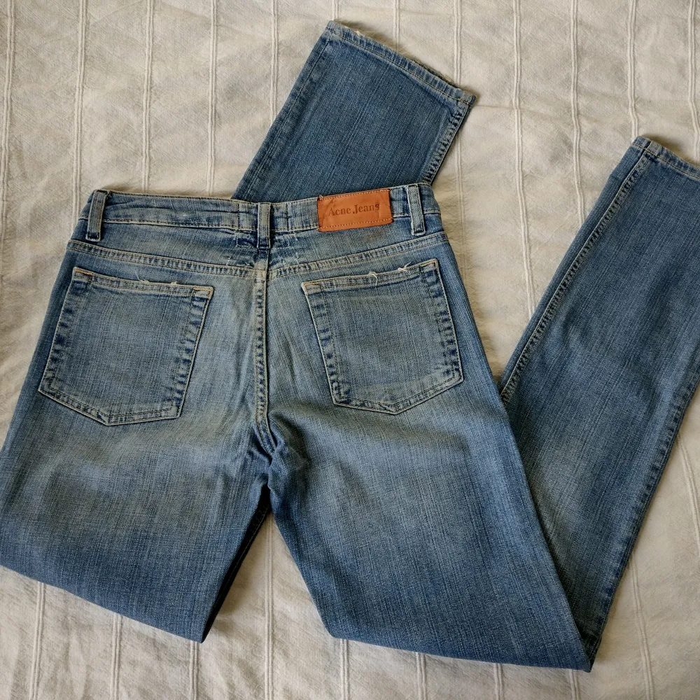 Blå vintage jeans med slitna detaljer från Acne. Modellen heter Hep Nice och är lågmidjade med raka ben. Skitsnygg modell och tvätt. 98% bomull och 2% elastan. Sparsamt använda. Lite missfärgade under läderlappen i bak (kanske går bort i tvätten).. Jeans & Byxor.