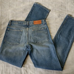 Acne Action Jeans - HEP NICE - 27/32 - blå vintage jeans - Blå vintage jeans med slitna detaljer från Acne. Modellen heter Hep Nice och är lågmidjade med raka ben. Skitsnygg modell och tvätt. 98% bomull och 2% elastan. Sparsamt använda. Lite missfärgade under läderlappen i bak (kanske går bort i tvätten).
