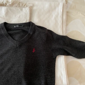 Stickad tröja  - Stickad snygg mörkgrå tröja från Ralph Lauren!! Sparsamt använd. Skulle säga att den sitter som S. Frakt ingår i priset! Kan mötas upp i centrala Stockholm.