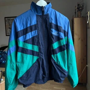 Carlton tracksuit jacka - Säljer denna tunga gammla tracksuit jackan från Carlton. Den har små fickor med dragkedja fram. Resor nere och vid handlederna. Passar Xs/s sitter overzised. 💚💙