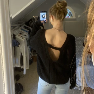 Svart stickad tröja med öppen rygg - Tröja som inte kommer till användning. (Spegeln är smutsig) 