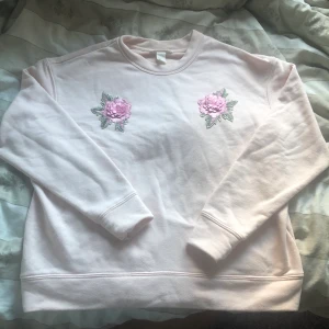 Rosa tjocktröja med blom-detaljer - Köpte second hand för två-tre år sen. Har bara haft på ungefär 2 gånger. Bra skick. Ganska tunn, somrig, mysiga 