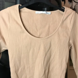 Beige kortärmad urringad topp - Längden på ärmarna går ungefär till mina armbågar :) På Lappen står det storlekar från M/L men passar perfekt på folk som har XS/S