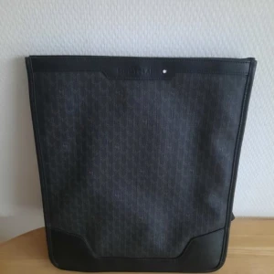 Montblanc axelremsväska  - Perfekt för surfplatta, mindre dator och dokument  Utmärkt skick  Svart  Läder  Tillverkad i Italien  Höjd: 30cm Bredd 25cm Djup: 7cm Serienummer:BN 311 Justerbar axelrem  1 mindre fack inuti samt 2 pennhållare 