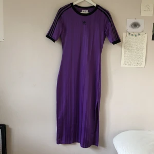 Lila adidas klänning - Lång as ball lila adidas klänning med slit. Säljer för att jag aldrig får användning för den, men den är sååå snygg. Har fått den av min pappa men aldrig använt så den är som ny