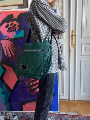 Messenger väska - En grön axelremsväska med många fack och blixtlås i tyg
