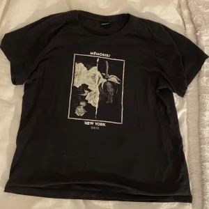 Svart t-shirt  - En svart t-shirt med ett tryck i mitten. Använd 1-2 gånger. Tröjan kommer att strykas innan leverans!😌