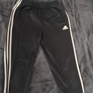 Adidasbyxor  - Grå Adidasbyxor med fickor och dragkedja på benen. Använda.