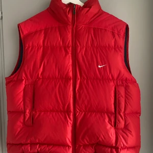 Dunväst Nike  - Röd dunväst från Nike. Använd ett fåtal gånger. Storlek XL, jag skulle säga att den är unisex. Köparen står för frakten. Kan mötas upp i Uddevalla och Trollhättan. Finns även möjlighet att mötas upp i Göteborg. 