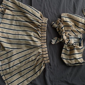 Strand plagg/ Sommar - Säljer en slags strand plagg eller bara en 2-piece set från Boohoo, Aldrig använd. Jätte skön material. I färgen Beige/Svart/Vit. Såna band på överdelen som man kan knyta o justera som man vill