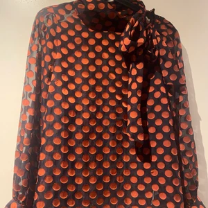 Mörkblå blus med organge prickar med rosett  - Tunn blus