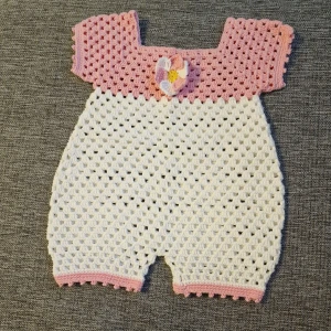 Baby overall - Denna fina mysiga overall har jag virkat. Garnet är av bomull. En knapp av plast finns på baksidan. Tvättas i 30 grader. Passar barn vid ca 6 månader.  Finns i rök och djurfritt hem. Köparen står för frakten.