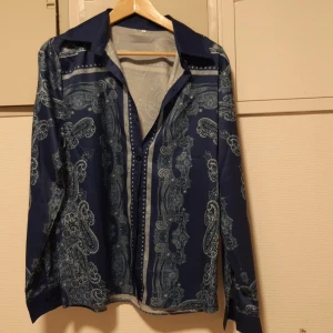 Skjorta L - Skjorta i polyester glansigt tunnt material storlek L. Alldrig använd felköp