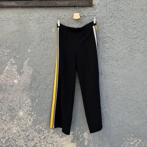 Svarta byxor med gula revärer - Svarta byxor med gula revärer. Bekväm och stretchig trikå. 96% polyester, 4% elastan. Älskar dessa byxor men upplever attt de är för korta för mig (176cm med långa ben). Swish is queen 🌞🌻
