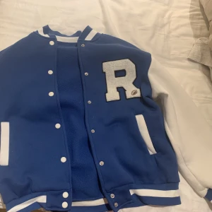 BLÅ & VIT HIGJSCHOOL SOCCER TRÖJA - Hejjj! Säljer en tvär snygg tröja som är klassisk ”highschool soccer” tröja i färgerna blå och vit! Går att stänga med knappar och har ett snyggt R tryck framtill. Jag är tjej och använder den men den fungerar givetvis för killar också! Frakt tillkommer🫶🏼 