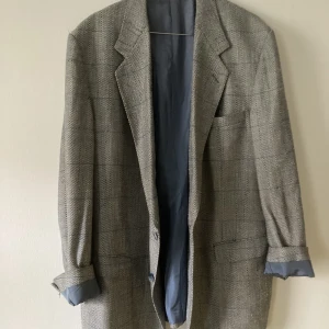 Over size kavaj stl 46 - Fin kavaj från SIR. Stor i storleken för kvinnor stl 46-48. I ylle, rutig i diskreta färger.