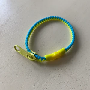 Färgglatt y2k armband - Nostalgiskt armband i motiv av en dragkedja! Dessa är populära för tidigt 2000-tal. Köp nu! 13 kr frakt med frimärke om betalning sker via swish.