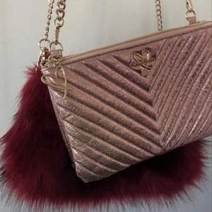 Helt ny oanvänd Victoria’s secret väska i metallic rosa färg. Går att ta av banden ifall man vill använda den som purse eller necessär. 