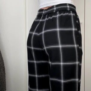 Checkered straight-legged trousers - Supersköna rutiga byxor med resår från Monki, sparsamt använda och i gott skick. Brukar ha svårt att hitta byxor som passar bra i midjan och låren men tycker dessa sitter perfekt! Är 173cm som referens till bild 3.