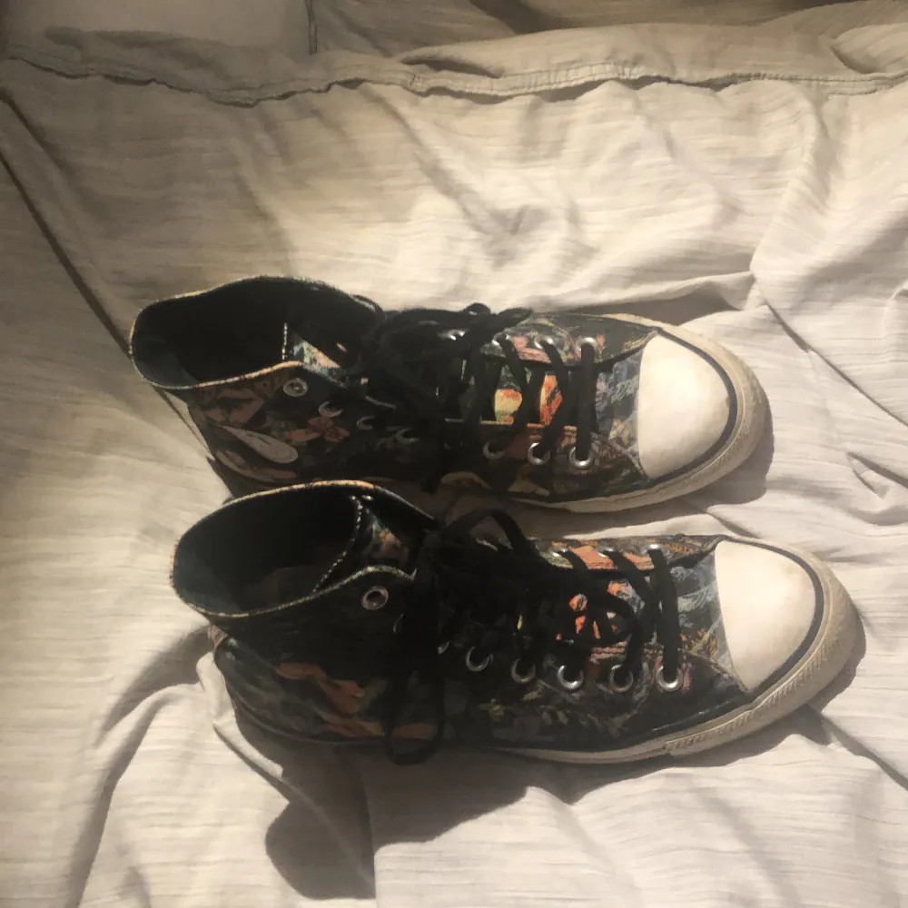 Dessa converse har blomliknande figurer. Använda men inte så slitna och dom är hela och inte sönder. . Skor.