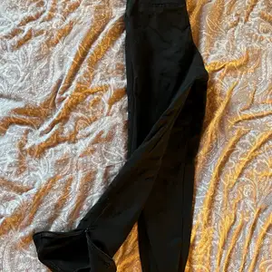 Ett par svarta högmidjade kostymbyxor från bikbok i stl 34. De har även en dragkedja längst ned på byxbenen så man kan välja om man vill ha en slits eller inte. De är något noppriga men det är lätt att ta bort själv om man skulle vilja. 