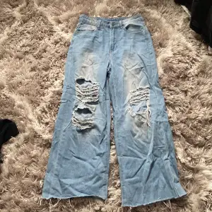 Jeans med hål i knäna som r baggy 