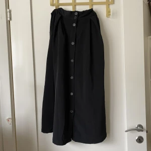 Kjol monki - Svart långkjol med knappar och fickor. Använd 1 eller två gånger så den är i nyskick :)