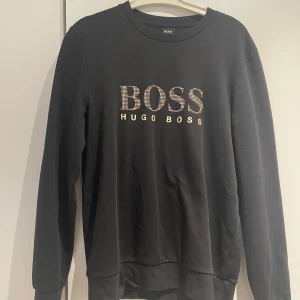 Hugo Boss sweatshirt - Guld/svart Hugo Boss sweatshirt som behöver komma till användning då den bara har hängt i garderoben! 10/10 i skick Storlek L, sitter bra på dig som har M också