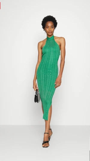 Grön glittrig klänning Gina tricot strl M  - Grön halterneck klänning från Gina tricot. Aldrig använd fint skick. Lite lösa trådar baktill där man knäpper. 