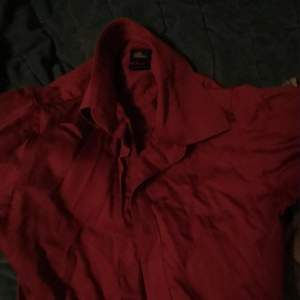 En mörk röd Skjorta som är oanvänd på ett lågnt tag men fortfarande är i god kvalité Storlek är 34/35 extra small