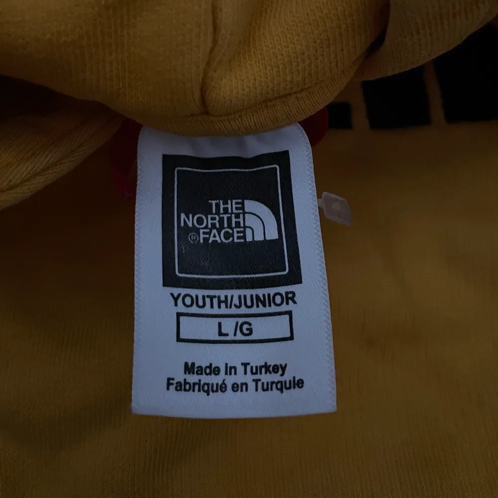 Fin gul North Face hoodie. Säljer billigt pga hål vid högra sidan av magfickan, ingenting som inte går att laga💛. Tröjor & Koftor.