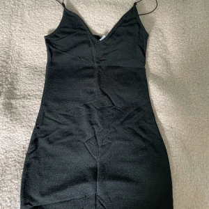 Svart glittrig klänning - Svart klänning med silverglitter, från H&M divided, passar perfekt till fest och nyår! I superfint skick!