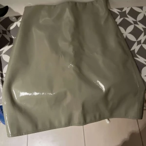 GinaTricot Kjol - En fin grön lackkjol från Gina Tricot. Kjolen är i fint skick och är knappt använd.  Köparen står för frakten 💕💕