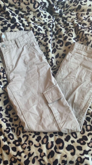 cargo byxor gina tricot  - säljer beige cargo byxor från gina tricot i storlek 32. jättebra skick men en supereliten rispa längst upp där fram som man inte ens ser på bilden för den är så liten. köpte för 500. säljer för 150. säljer pga använder ej längre❤️❤️ kontakta vid intresse!!