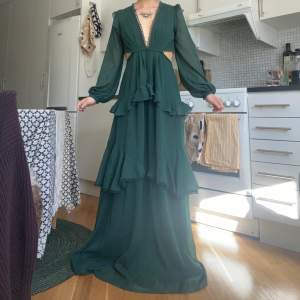 Grön långklänning från Asos Design, storlek 36/S, använd två festtillfällen. Superfin skogsgrön färg med volang, dragkedja på nederdelen baktill och knappar längs ryggen upptill! Superfin till fest/bal/bröllop å liknande 🫶