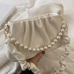 En fin beige vit väska, med pärlor. Smidig att ha med och du får plats med lite smått blandat. 