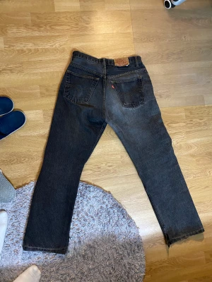 Mörkgrå Levis 501 - Rak 501 modell i snygg mörkgrå färg. Klippta till bootcut vilket ger ett fint fall i benet.  Står på lappen att det är 34x36 men det passar mer som en 30x30 ungefär.  Kan mötas i Stockholm annars står köparen för frakten.