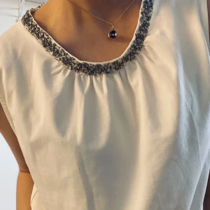 Vit blus med detaljer upptill - Superfin vit blus med silverdetalj längst halsen. Är i bra skick! 