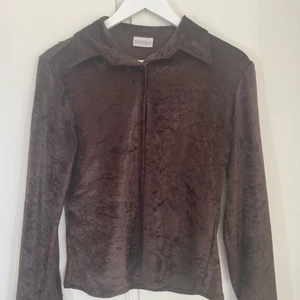 Brun sammetsskjorta från Humana - Brun skjorta i sammet. Lätt figursydd med spetsig krage. Knappt använd å i bra skick! 